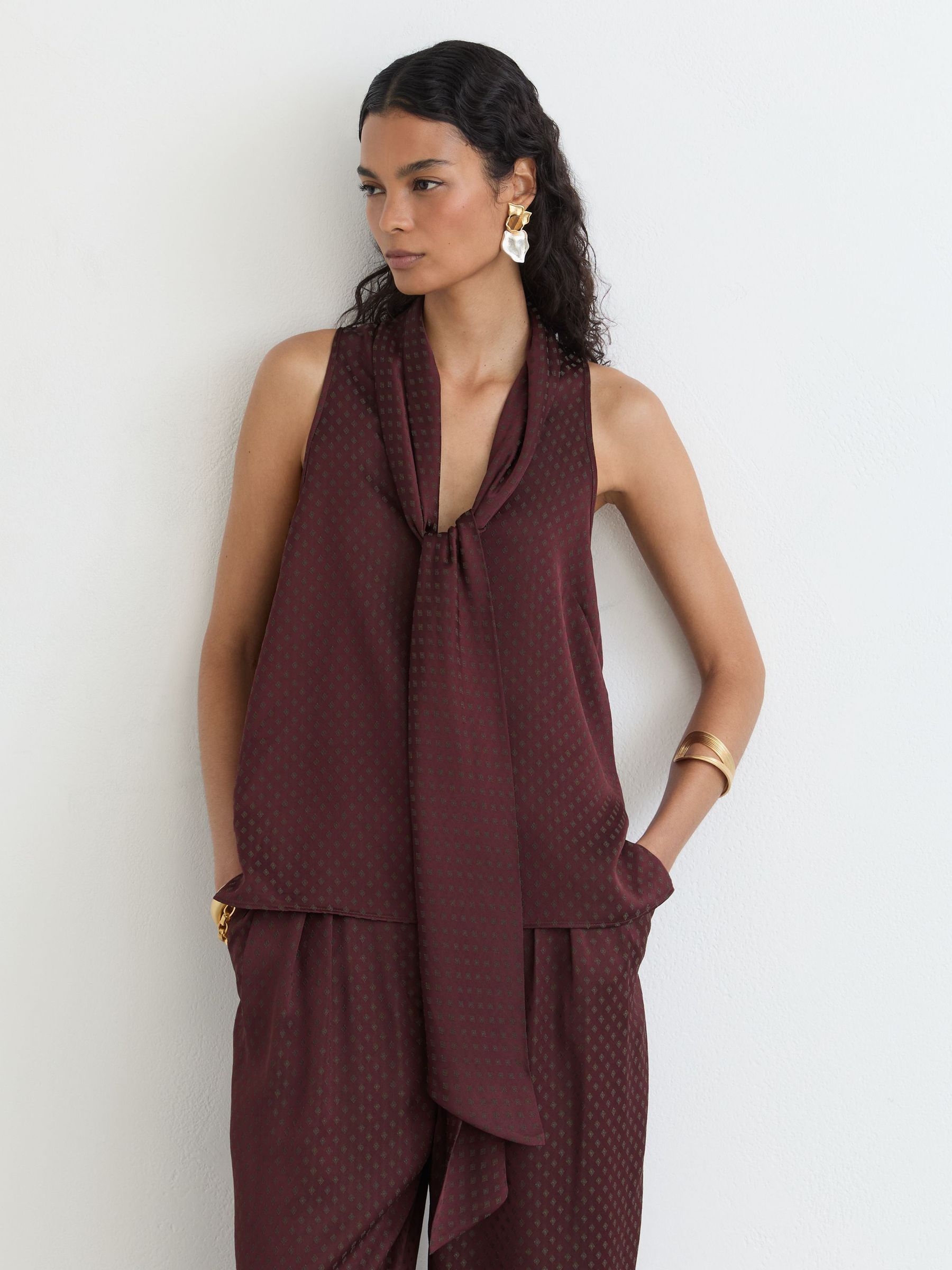 Jacquard Tie-Neck Sleeveless Top in Burgundy - Image 1 of 8 Jacquard Tie-Neck Sleeveless Top in Burgundy - Image 1 of 8