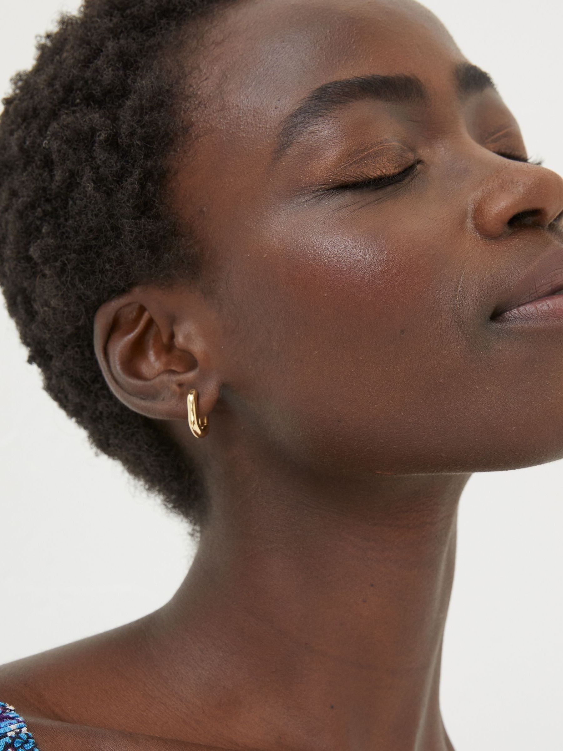 Gold Tone Oval Huggy Hoop Earrings - Image 1 of 3 Gold Tone Oval Huggy Hoop Earrings - Image 1 of 3